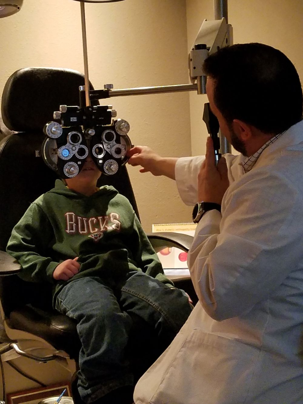Dr. Gospodarek examining a young patient behind the phoropter